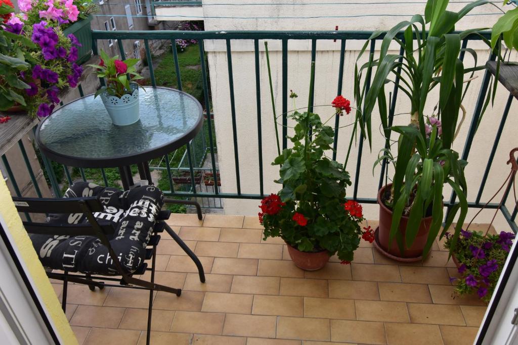 un balcón con una mesa y algunas plantas y flores en Apartment Morena, en Zagreb