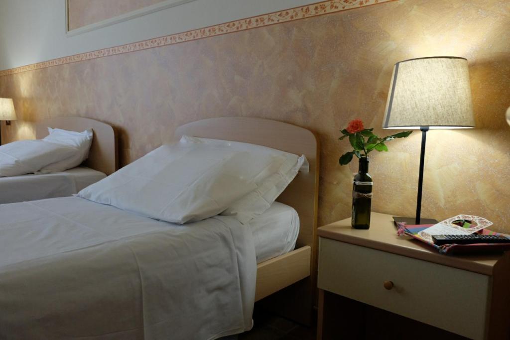 Habitación de hotel con cama y mesa con lámpara en Hostel il Tetto, en Melfi