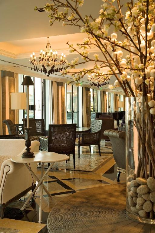 a lobby of a hotel with a table and chairs at Grande Real Villa Itália Hotel & Spa in Cascais