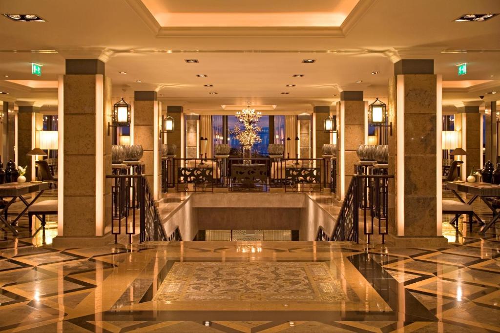 a lobby of a hotel with tables and chairs at Grande Real Villa Itália Hotel & Spa in Cascais