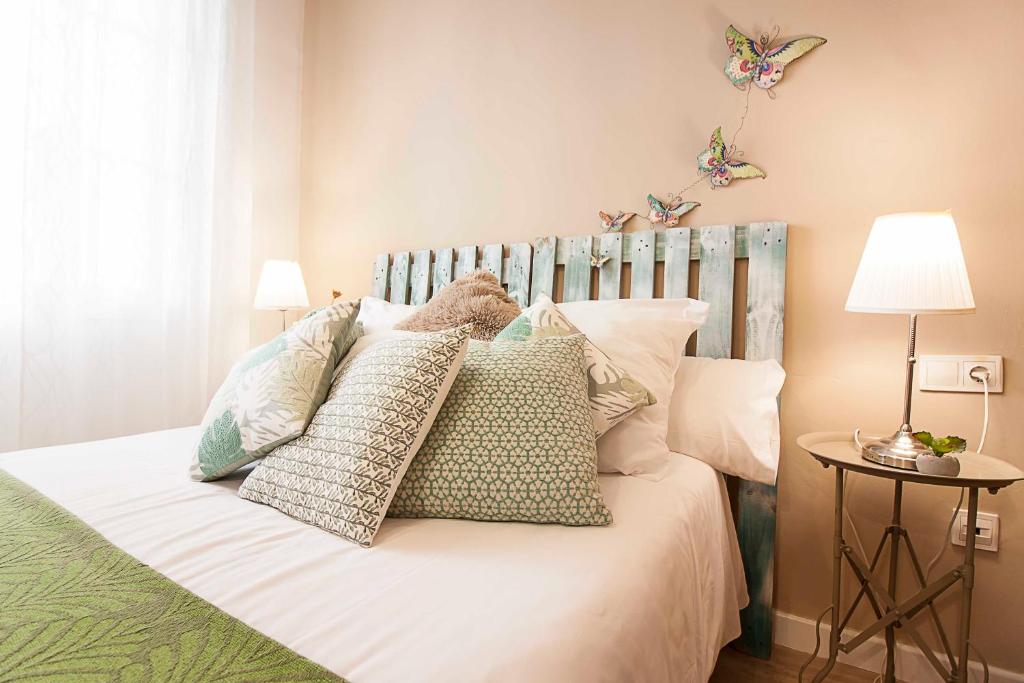 a bedroom with a bed with pillows and butterflies on the wall at Malaga Center Flat Historic Center in Málaga
