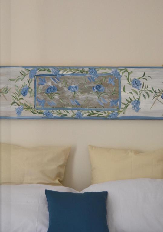 obraz na ścianie nad łóżkiem z poduszkami w obiekcie Casa Jolanda B&B w mieście Palermo