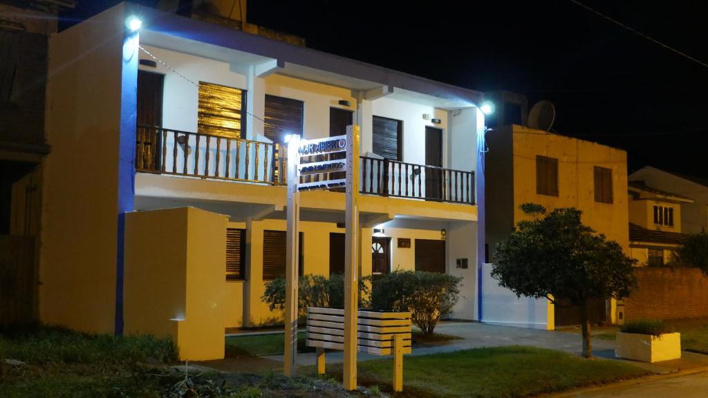 Casa blanca y amarilla con balcón por la noche en Complejo Mar Abierto en Santa Clara del Mar