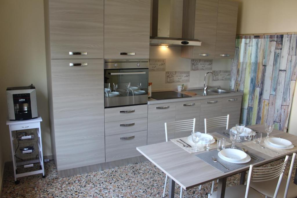 een keuken met een tafel met stoelen en een wastafel bij Brezza di Lago in Salò