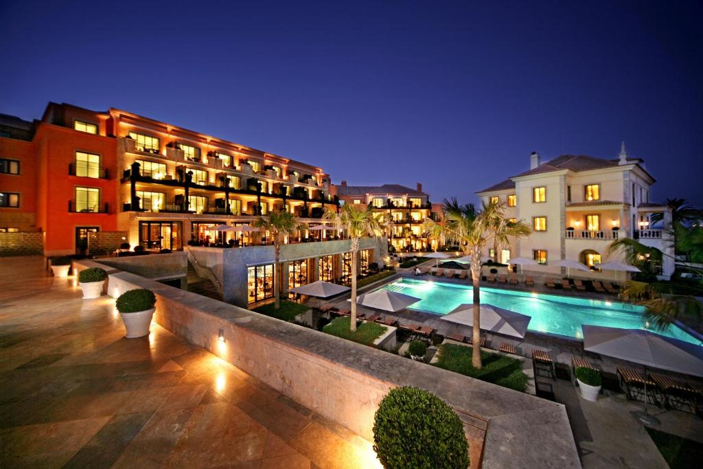 a hotel with a swimming pool at night at Grande Real Villa Itália Hotel & Spa in Cascais