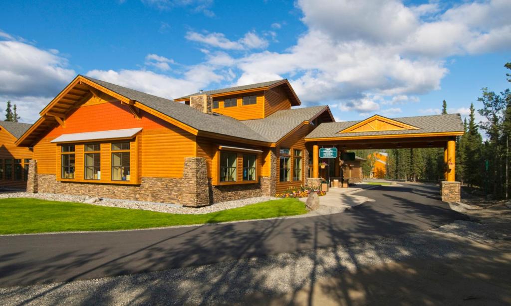 a yellow house with a gambrel roof at Denali Park Village in McKinley Park