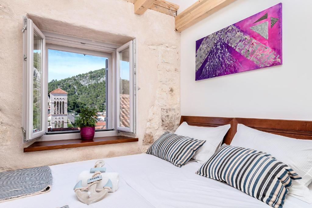 a bedroom with a white bed and a window at Successus Old Town House in Hvar