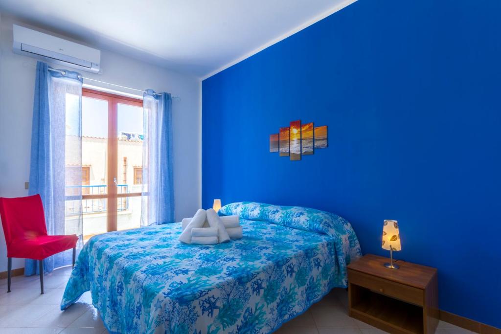 サン・ヴィート・ロ・カーポにあるResidence I Pianetiの青いベッドルーム(ベッド1台、赤い椅子付)