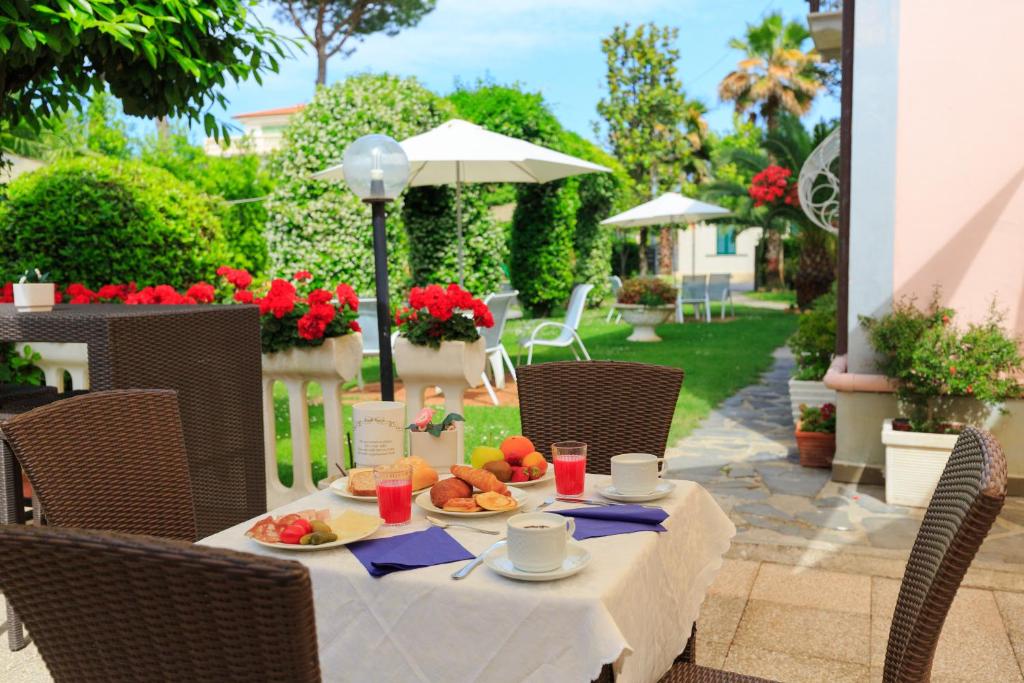 a table with a plate of food on a patio at Hotel Ambra in Forte dei Marmi