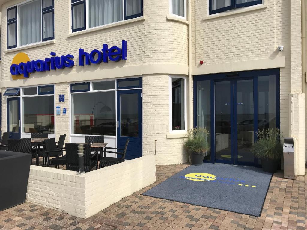 ein Restaurant mit Tischen und Stühlen außerhalb eines Gebäudes in der Unterkunft Aquarius Hotel in Scheveningen