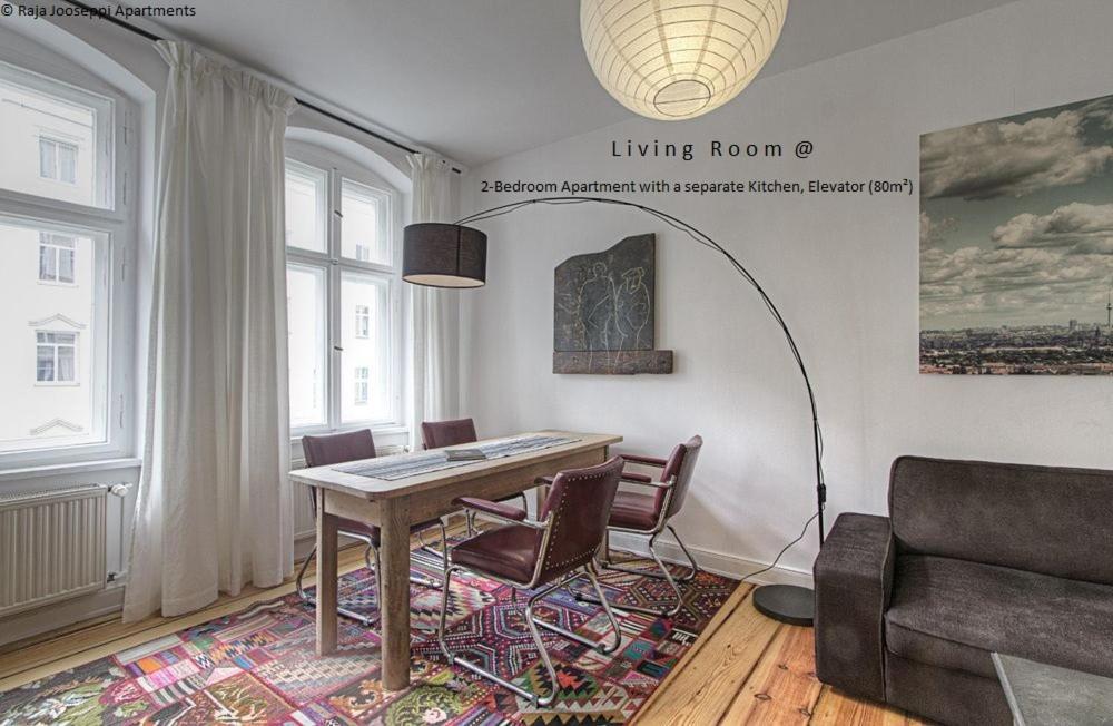 - un salon avec une table, des chaises et un canapé dans l'établissement Raja Jooseppi Apartments, à Berlin