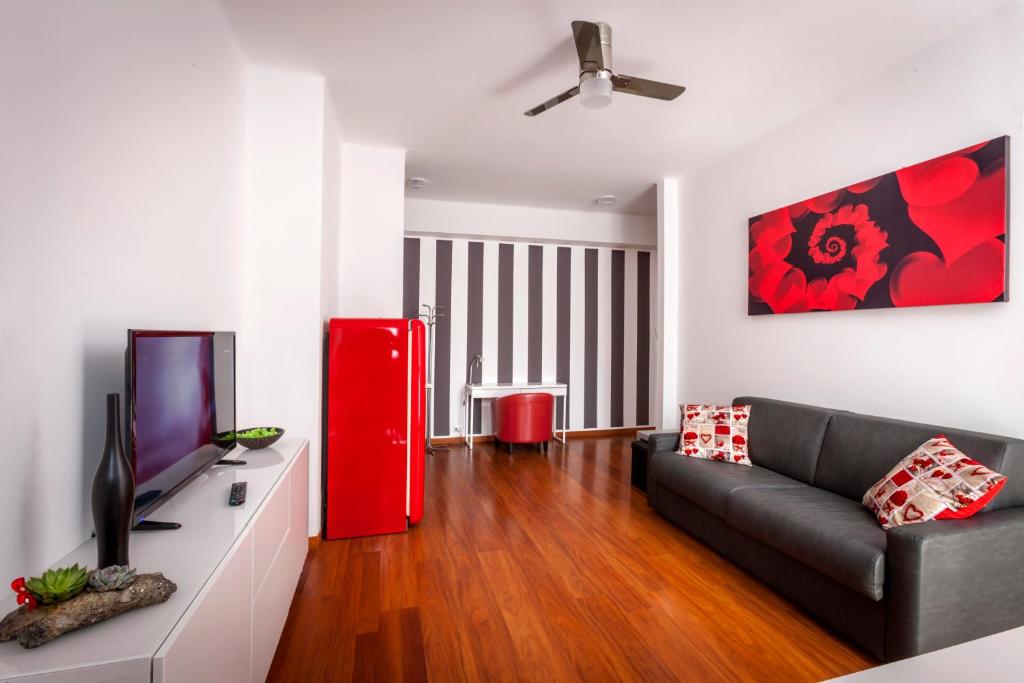 a living room with a black couch and a red refrigerator at Bright House in Milan in Milan