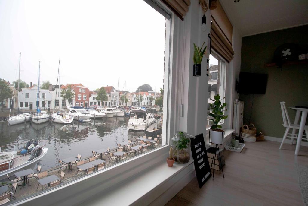 a window with a view of a marina with boats at De Kade in Goes