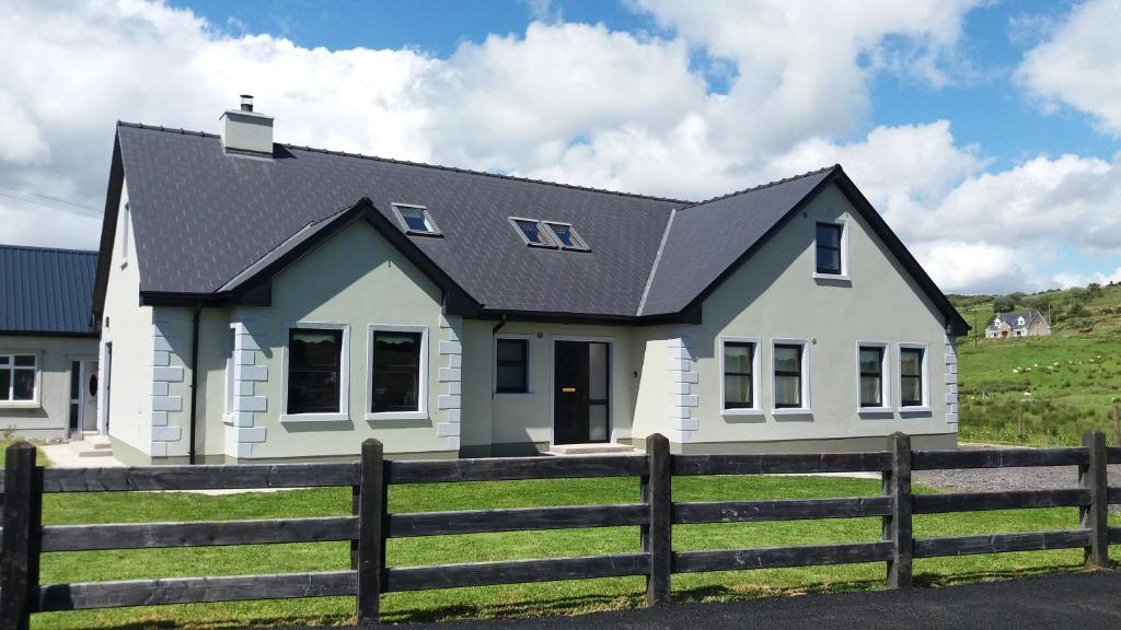 una casa blanca con techo negro en Leghowney House, en Donegal