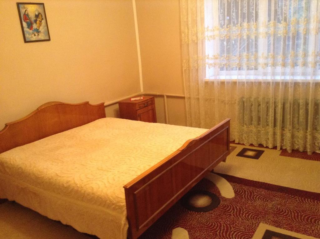 een slaapkamer met een bed voor een raam bij Вікторія in Tatariv