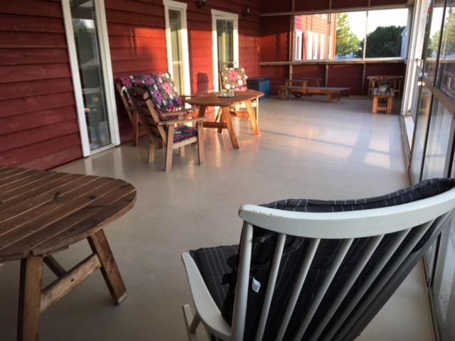 a screened in porch with chairs and tables and a table at Borrby Frö B&B in Borrby