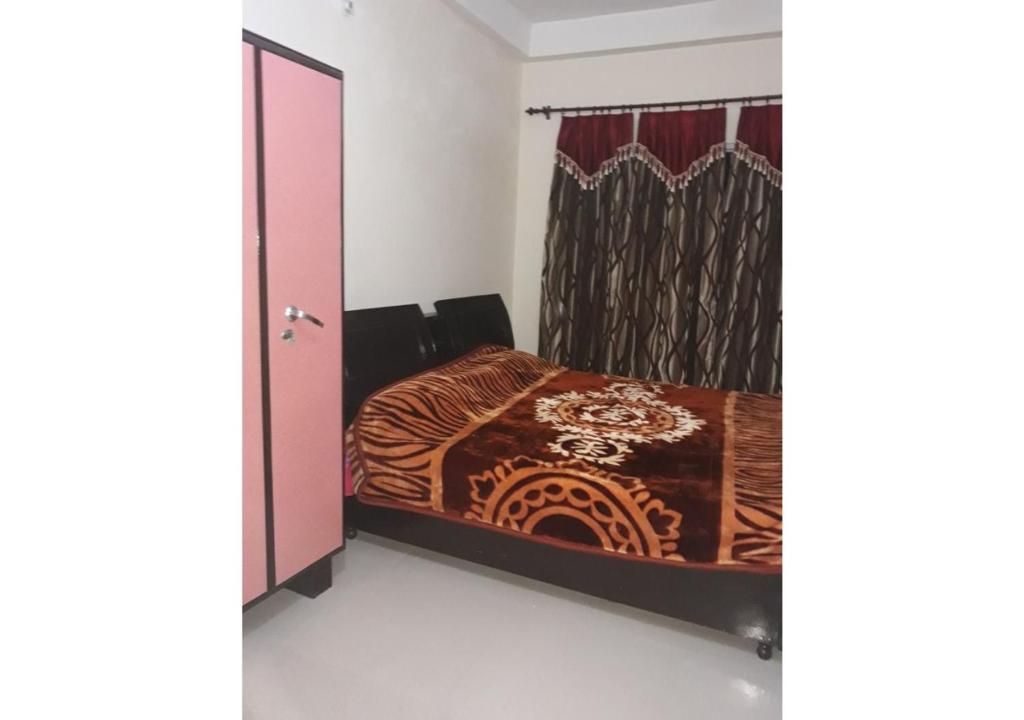 a bedroom with a bed and a pink door at 2BHK Furnished Apartments in Dalhousie