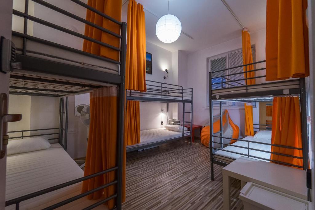 a dorm room with three bunk beds and a desk at Pijama Hostel in Plovdiv