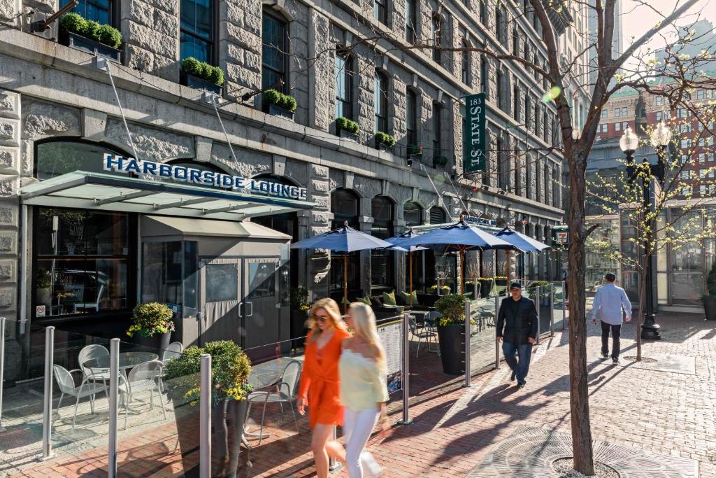 a woman walking down the street with an umbrella at Harborside Inn in Boston