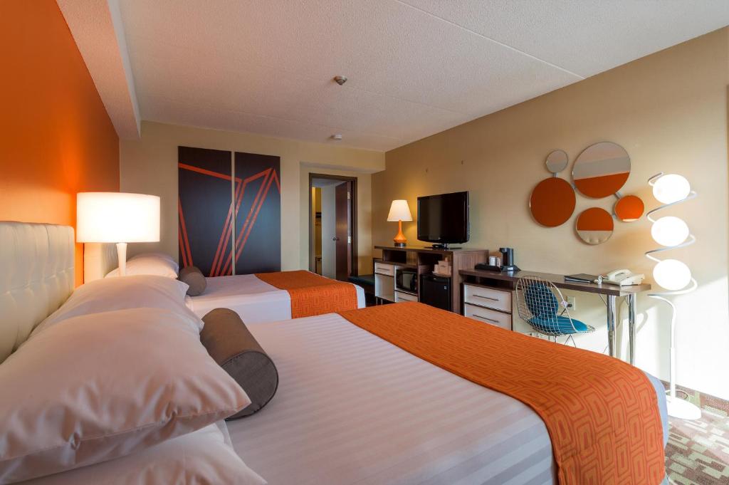 a hotel room with two beds and a television at Howard Johnson Plaza by Wyndham by the Falls Niagara Falls in Niagara Falls