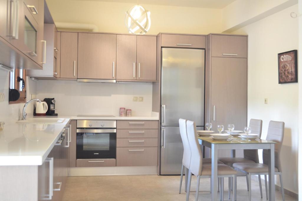 a kitchen with a table and chairs and a refrigerator at Ariadni's Maisonette in Yiofirákia