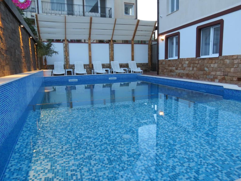 uma piscina com água azul num edifício em Aurora Guest House em Golden Sands