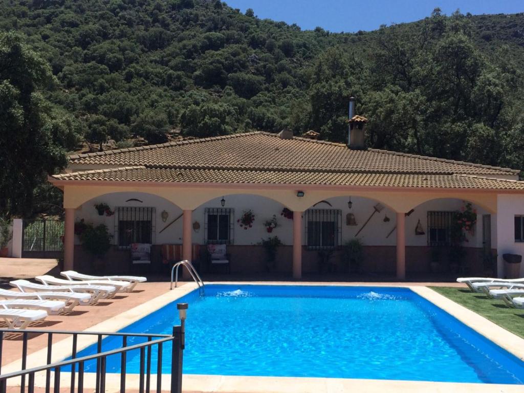 a villa with a swimming pool in front of a house at Villa La Quinta in Priego de Córdoba