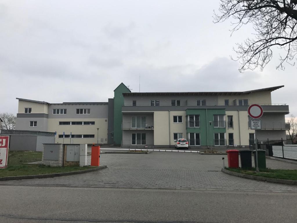 een groot gebouw met een parkeerplaats ervoor bij Apartman c.8 Magnolie in Třeboň