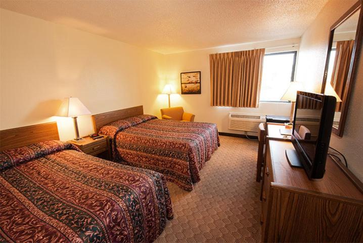 a hotel room with two beds and a television at Superior & Sage Hotel in Superior