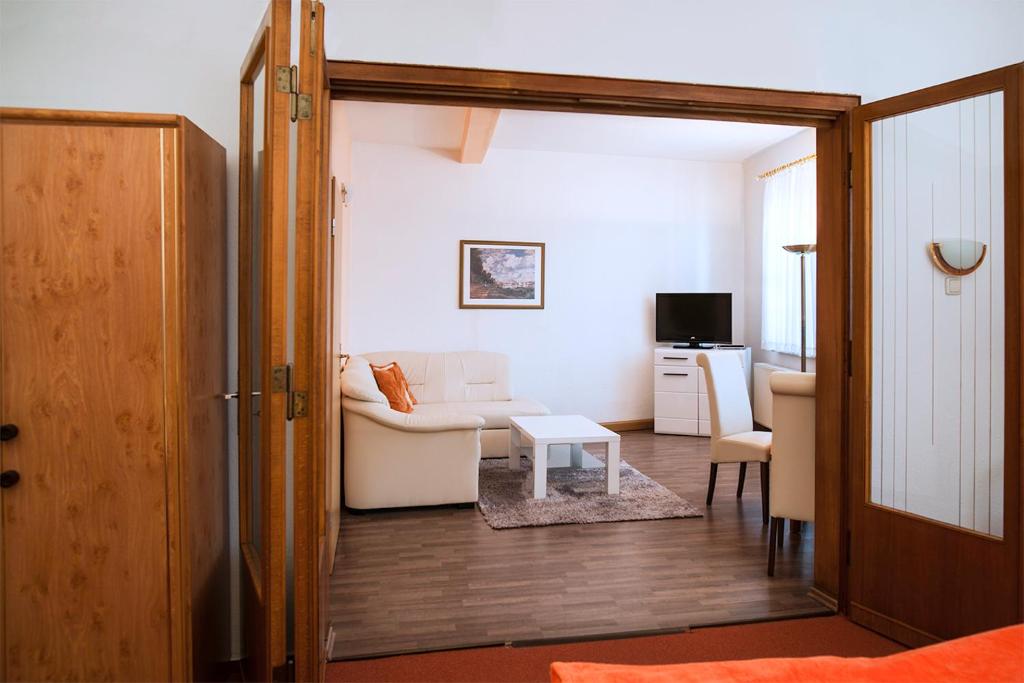 un soggiorno con divano bianco e tavolo di Hotel Weltrich a Saalfeld