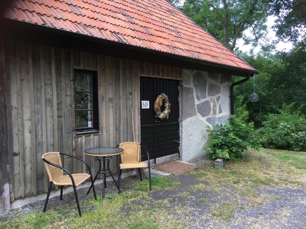 a table and chairs in front of a cabin at Stenlängan Lodge in Lönsboda