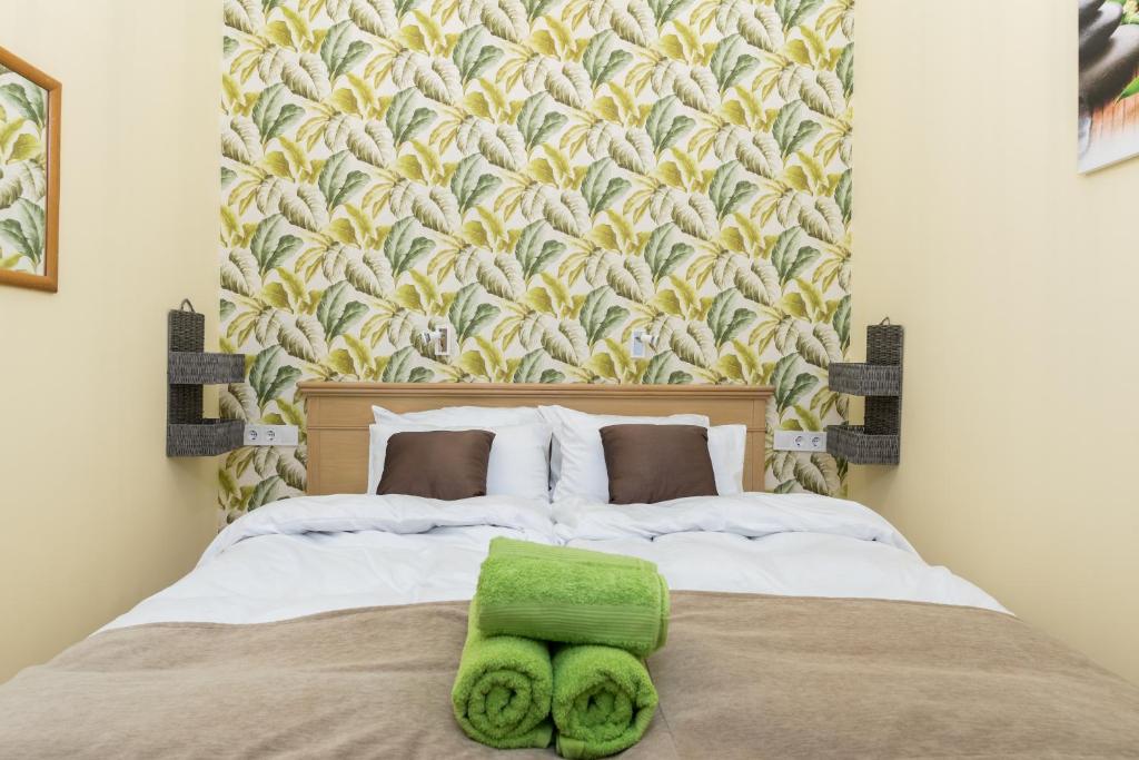 a bedroom with a bed with a green towel on it at Jungle design apartment in Budapest