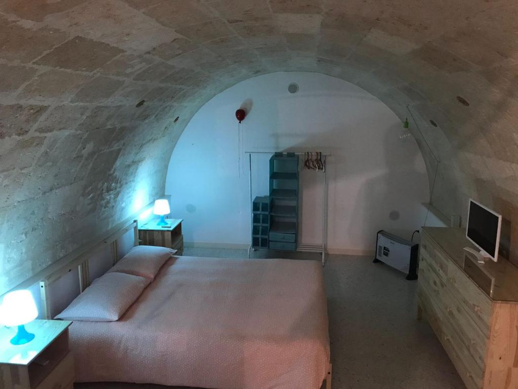 una camera con un grande letto in una parete in pietra di casa vacanza Regina a Grottaglie