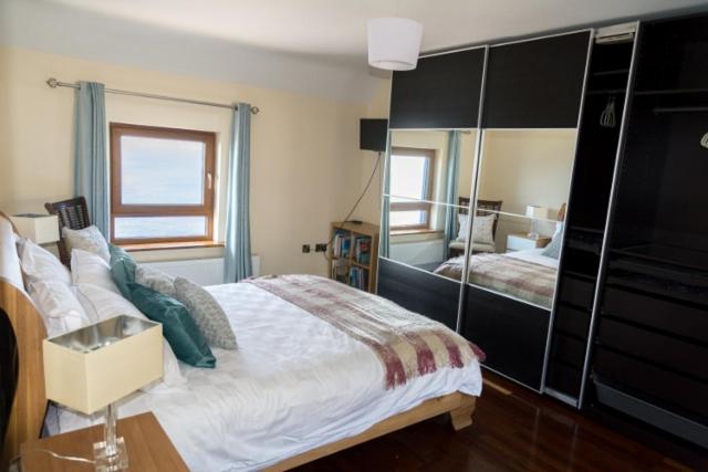 丁格爾的住宿－Atlantic rest，一间卧室设有一张大床和一个大镜子
