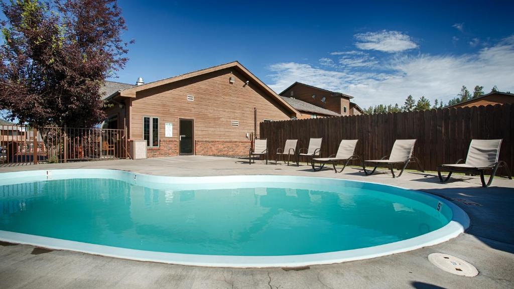 a swimming pool in a yard with chairs and a house at Black Hills Luxury Suites in Hill City