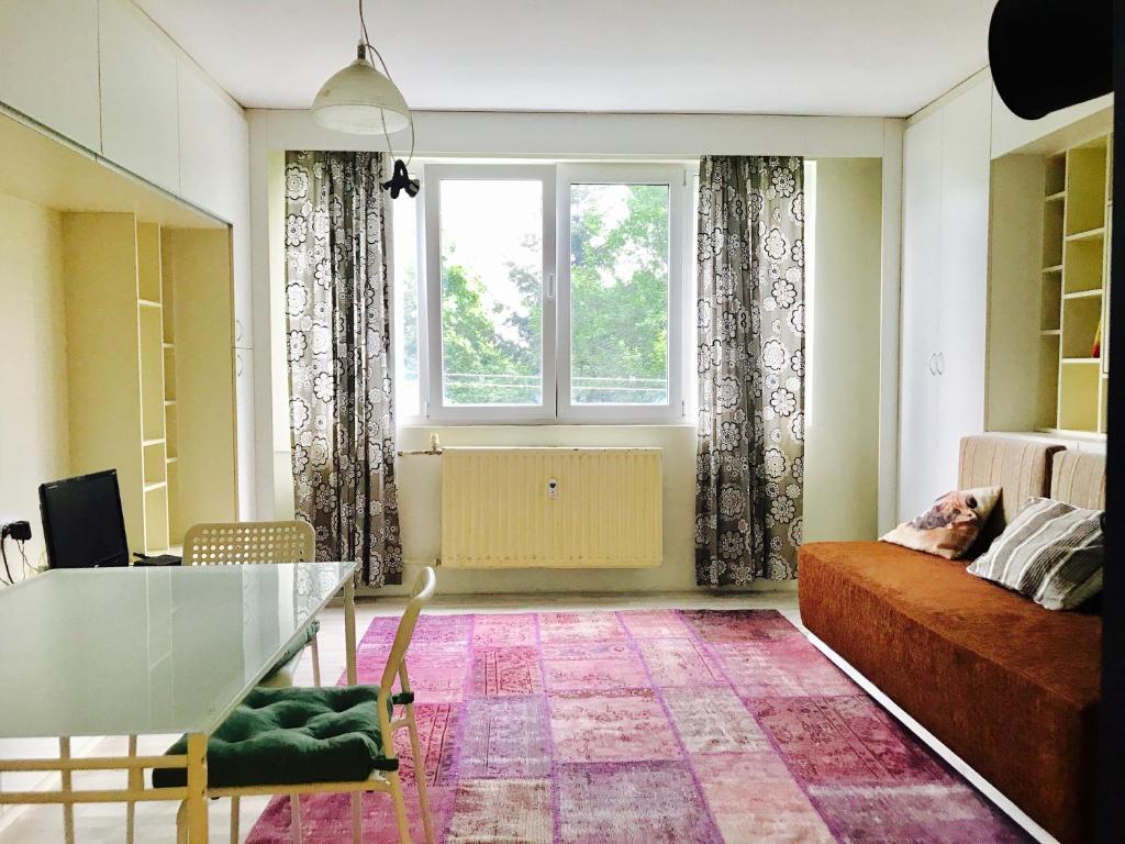 a living room with a couch and a window at Modern Studio 20 Meters from Mladost 1 Metro Station in Sofia