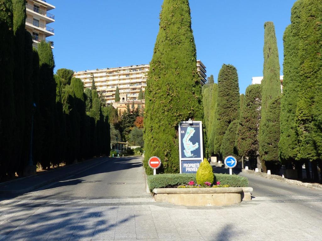 a street with trees and a sign in the middle at Abbaye de Roseland in Nice