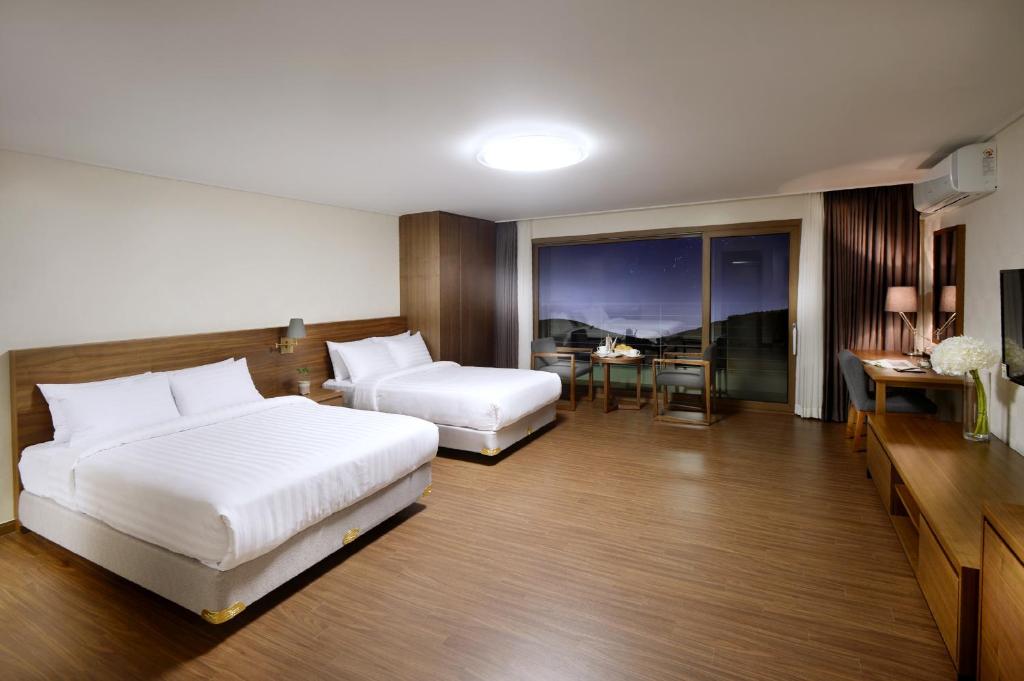 Postel nebo postele na pokoji v ubytování Jeju Aerospace Hotel