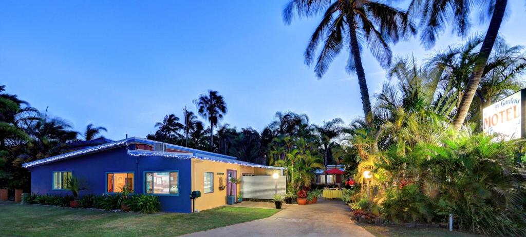 巴加拉的住宿－Bargara Gardens Boutique Villas，棕榈树蓝色和黄色的房子