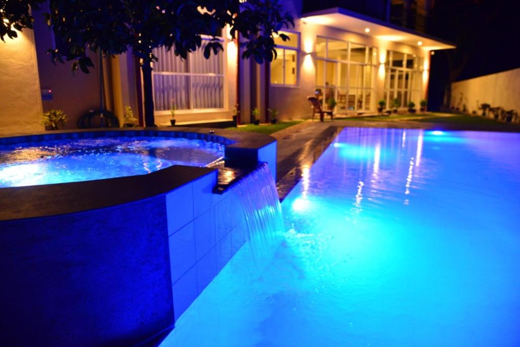 a swimming pool lit up at night with blue lights at Siri Tropical Retreat in Hikkaduwa