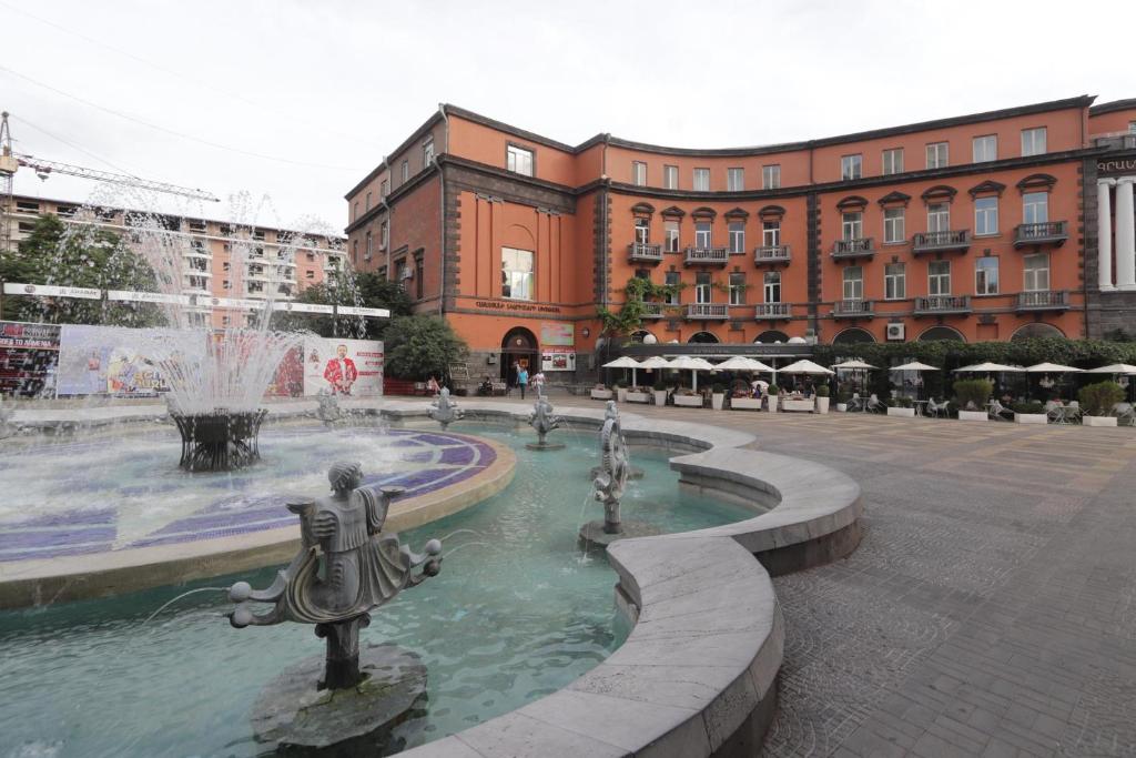 a fountain in the middle of a city with a building at Apartments Emili in Yerevan