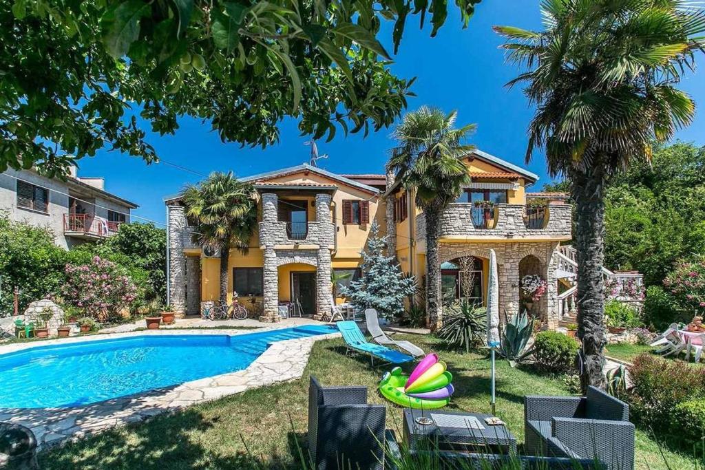 a villa with a swimming pool and a house at Villa Zara in Ližnjan