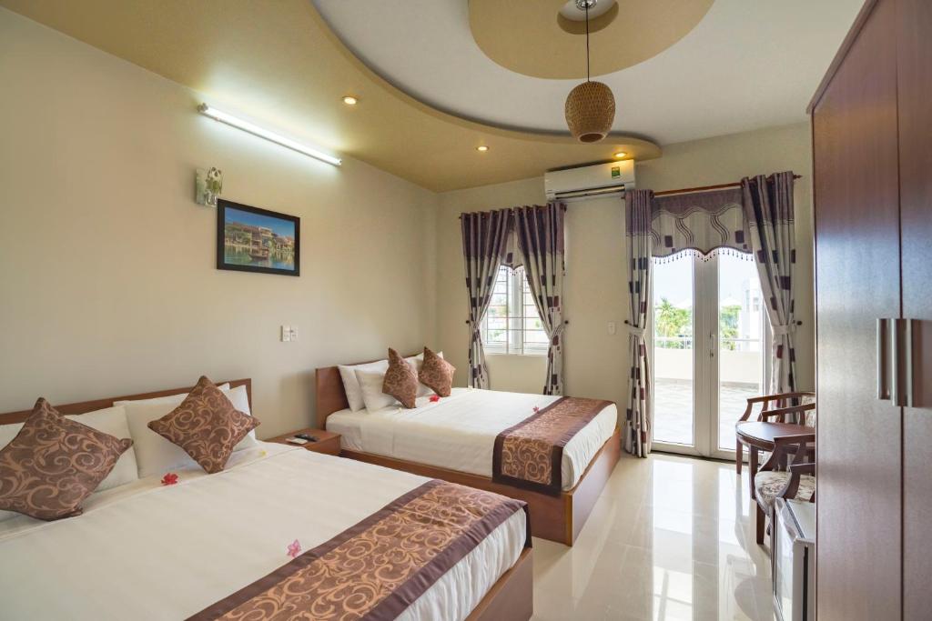 een hotelkamer met 2 bedden en een balkon bij My House Hoi An Homestay in Hội An
