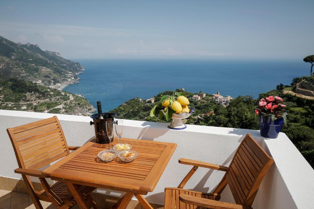 d'une table et de chaises sur un balcon avec vue sur l'océan. dans l'établissement L'Angolo dei Sogni, à Ravello