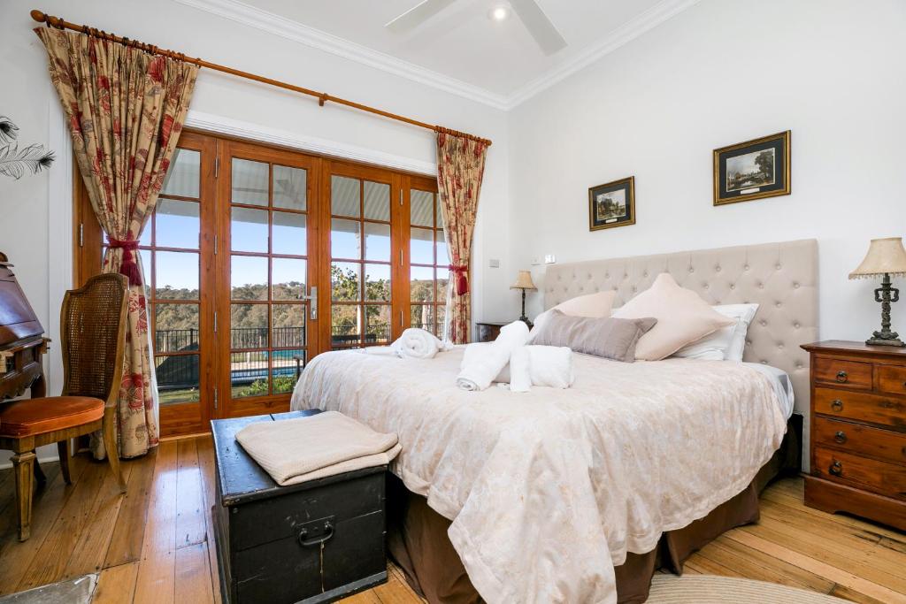 - une chambre avec un grand lit et une fenêtre dans l'établissement Taradale House Estate, à Taradale