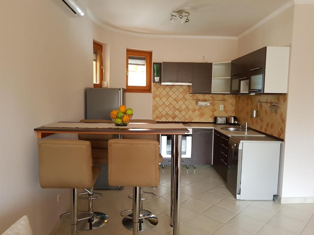 a kitchen with a table and some chairs in it at Napsugár Apartman in Balatonlelle