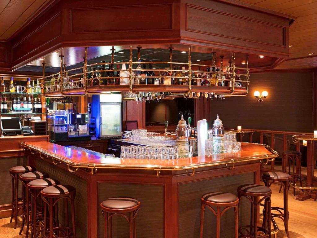 a bar with a bunch of glasses on it at Ibis Schiphol Amsterdam Airport in Badhoevedorp