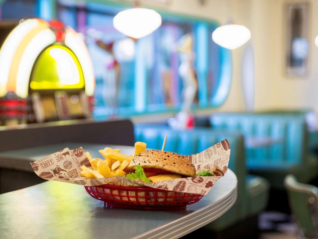 a sandwich and french fries in a basket on a table at Ibis Schiphol Amsterdam Airport in Badhoevedorp