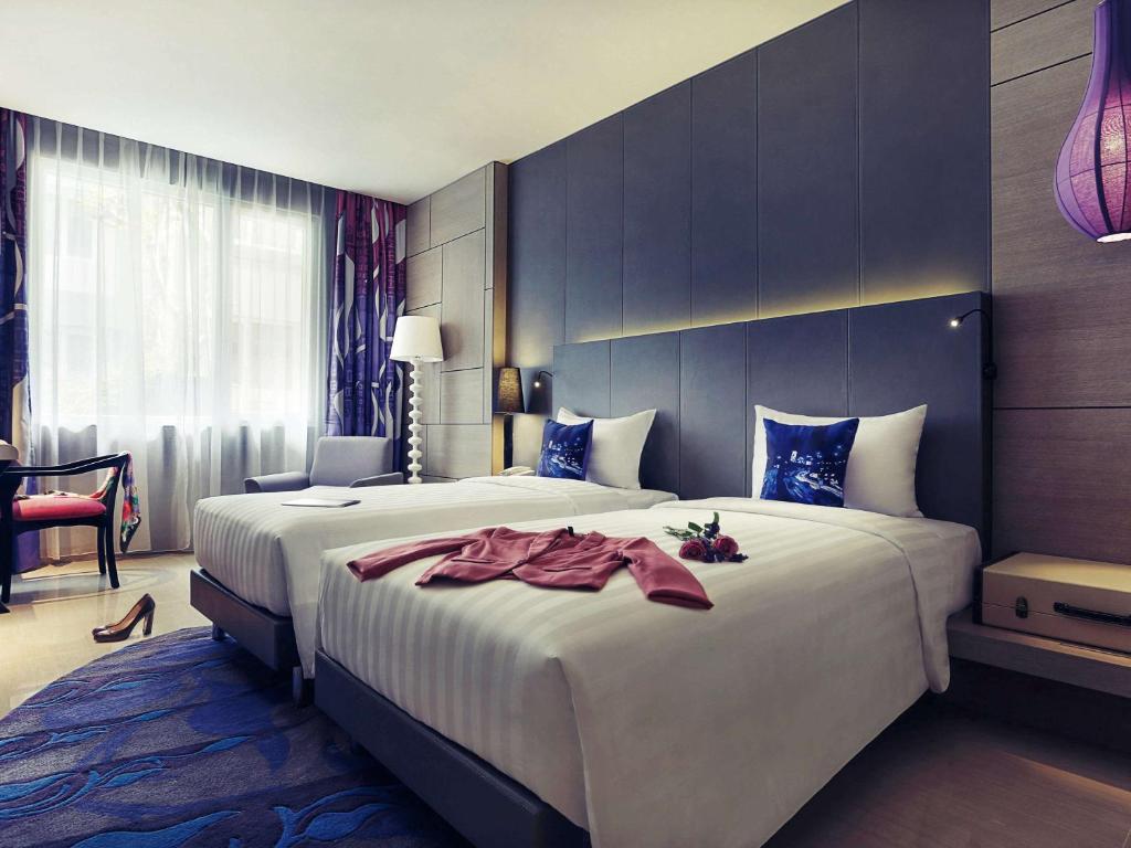 a hotel room with a large white bed in a room at Mercure Jakarta Sabang in Jakarta