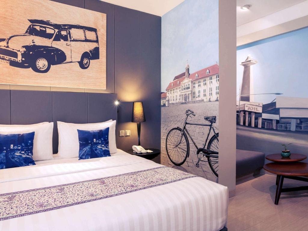 a bedroom with a bed and a painting on the wall at Mercure Jakarta Sabang in Jakarta